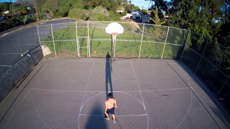 A-birds-eye-aerial-over-a-basketball-player-shooting-a-free-throw-on-an-outdoor-court