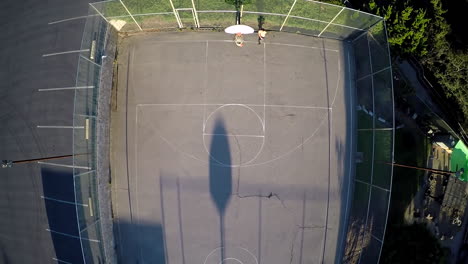 Eine-Vogelperspektive-über-Einem-Basketballspieler,-Der-Auf-Einem-Außenplatz-Zum-Korb-Fährt