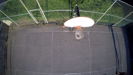 A-birds-eye-aerial-over-a-basketball-player-taking-a-jump-shot-on-an-outdoor-court