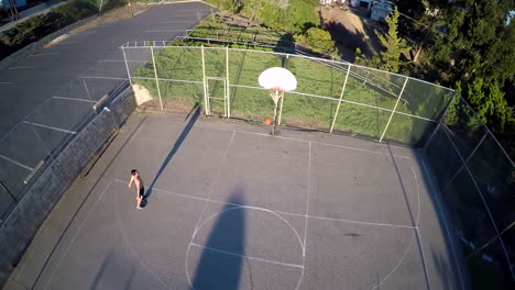 A-birds-eye-aerial-over-a-basketball-player-shooting-a-jump-shot-on-an-outdoor-court