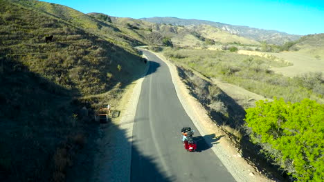 A-beautiful-aerial-shot-over-a-many-riding-his-Harley-motorcycle-on-the-open-road
