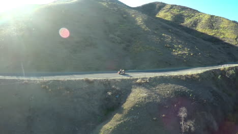 A-beautiful-aerial-shot-over-a-many-riding-his-Harley-motorcycle-on-the-open-road-1