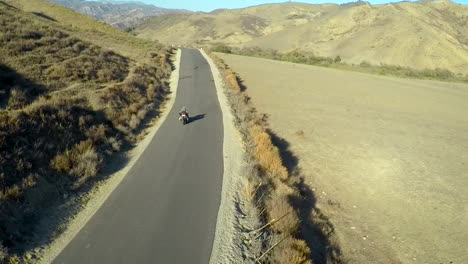 A-beautiful-aerial-shot-over-a-man-riding-his-Harley-motorcycle-on-the-open-road-5