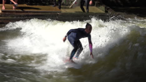 Surfers-brave-the-rapids-of-the-Eisbach-River-in-Munich-Germany-in-slow-motion