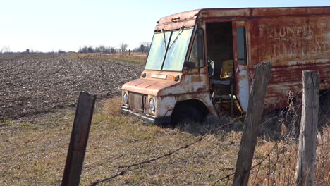 An-abandoned-delivery-truck-sits-in-a-plowed-field-in-the-Midwest