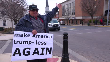 Ein-Mann-Hält-An-Einer-Amerikanischen-Straßenecke-Ein-Anti-Trump-Rallye-Schild-Mit-Der-Aufschrift-„Make-America-Trump-Less-Again“-Hoch