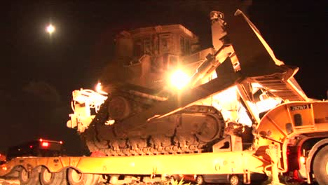 An-Israeli-armored-bulldozer-is-unloaded-from-a-flatbed-truck-for-night-patrol-along-the-Gaza-Strip