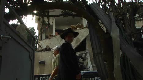 Los-Peatones-En-Haifa-Pasan-Por-Un-Edificio-De-Apartamentos-Destruido-Por-Un-Ataque-Con-Cohetes