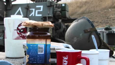 A-table-of-rations-stands-next-to-an-Israel-army-unit-and-their-tank