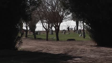 Zwei-Leute-Gehen-Spazieren-Und-Betrachten-Grabsteine-Auf-Einem-Friedhof-Am-Meer