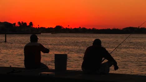 The-silhouette-of-two-men-fishing-at-sunset