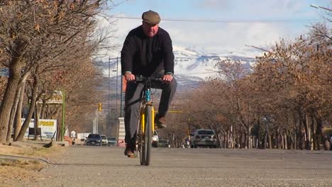 A-man-bicycles-along-a-country-road-