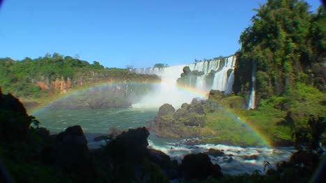 Argentina-Iguazu-Falls-wide-angle-with-rainbow-and-blue-sky-