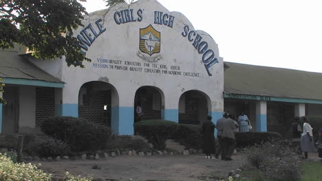 People-walk-past-a-highschool-in-Africa