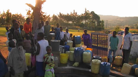 People-filling-up-canisters-with-water-from-a-water-pump