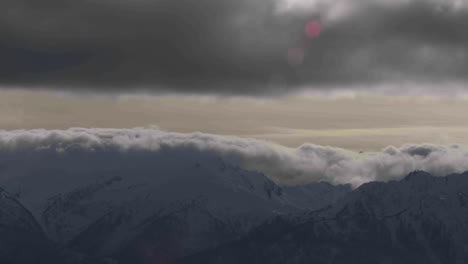 Eine-Schöne-Zeitrafferaufnahme-Von-Nebel-Und-Wolken,-Die-über-Die-Spitze-Einer-Bergkette-Rollen
