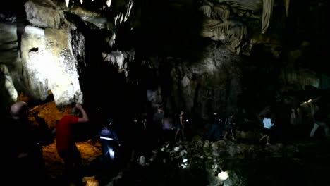 People-explore-a-dark-cave-with-flashlights