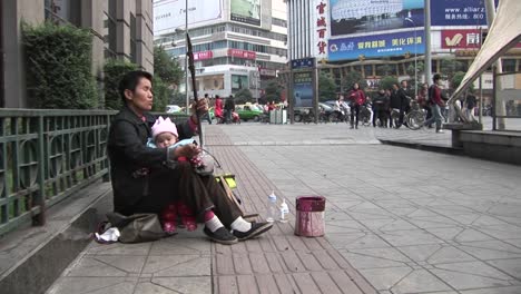 A-blind-man-plays-music-along-a-street-in-modern-China-1