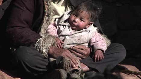 Un-Niño-Pequeño-Se-Sienta-En-Los-Brazos-De-Un-Pobre-Mendigo