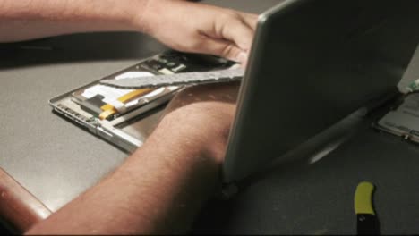 A-time-lapse-shot-of-hands-putting-together-a-laptop-computer