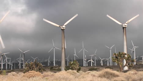Pan-across-windmill-generating-electrical-power-on-a-hillside-in-California