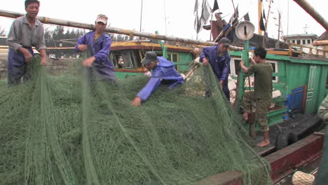 Männer-Sammeln-Fischernetze-Von-Einem-Boot-Aus