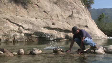 Man-removing-rocks-from-a-fish-barrier-on-the-Ventura-River-Preserve-in-Ojai-California