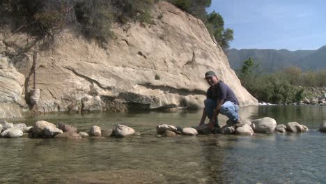 Man-removing-rocks-from-a-fish-barrier-on-the-Ventura-River-Preserve-in-Ojai-California-1