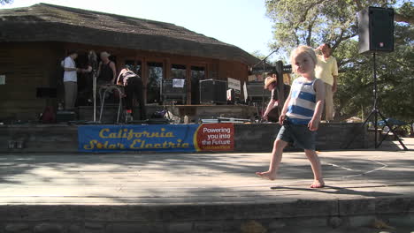 A-small-girl-dancing-along-on-a-stage-between-sets-in-Ojai-California