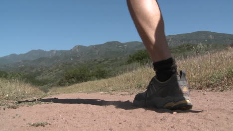 Low-angle-of-man-trail-running-on-the-Ventura-River-Preserve-in-Ojai-California