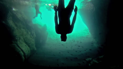 Free-diving-through-a-school-of-Black-Striped-Salema-fish-in-a-cave-at-Punta-Vicente-Roca-on-Isabela-Island-in-Galapagos-National-Park-Ecuador