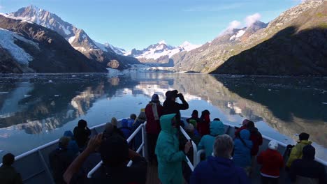 Tourists-on-the-bow-of-a-ship-entering-Johns-Hopkins-Inlet-in-Glacier-Bay-National-Park-Alaska