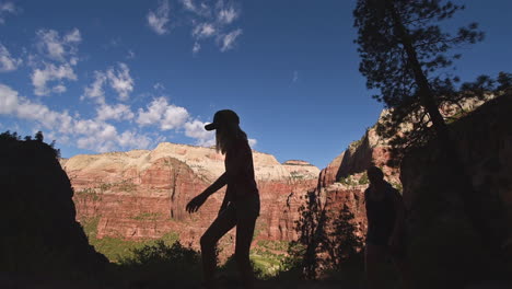 Tourists-mother-and-daughter-hike-in-Zion-national-Park-Utah-in-silhouette