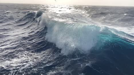 Nice-slow-motion-of-huge-blue-ocean-waves-cresting-from-a-boat