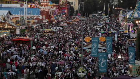 Tilt-down-to-overview-of-huge-crowds-at-an-amusement-park-or-Oktoberfest