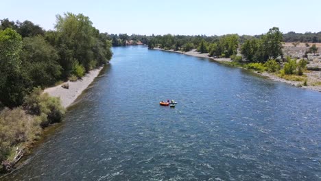 Toma-Aérea-De-Personas-Que-Viajan-En-Kayaks-Y-Embarcaciones-Personales-Inflables-En-El-Río-Americano-En-Sacramento,-California-2