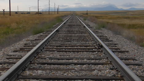 Railroad-Tracks-Stretch-Across-A-Grassy-Plain-Into-The-Horizons