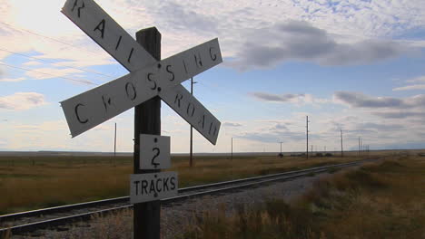 A-Railroad-Crossing-Sign-Rests-Stand-Next-To-Old-Train-Tracks