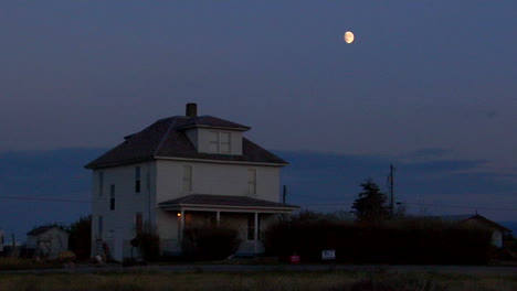 The-Moon-Rises-Over-A-Two-Story-House-In-The-Countryside