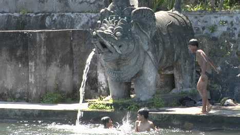 Boys-Jump-Into-The-Water-Of-A-Giant-Stone-Fountain-In-Bali-Indonesia