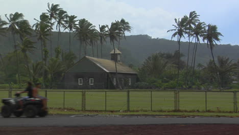 An-Atv-Passes-A-Distant-Church-On-A-Tropical-Island-During-A-Storm