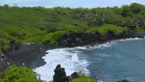 Ein-Hoher-Winkel-über-Wellen,-Die-In-Einen-Schwarzen-Sandstrand-In-Hawaii-Rollen