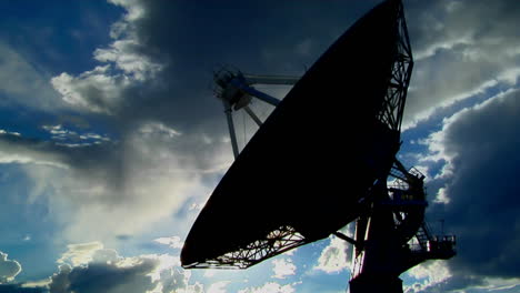 A-Satellite-Dish-Is-Moves-And-Is-Silhouetted-Against-The-Sky