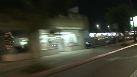 Ein-Auto-Fährt-Nachts-Eine-Straße-In-Studio-City-Kalifornien-Entlang,-Wie-Durch-Die-Heckscheibe-In-Einem-Winkel-Gesehen