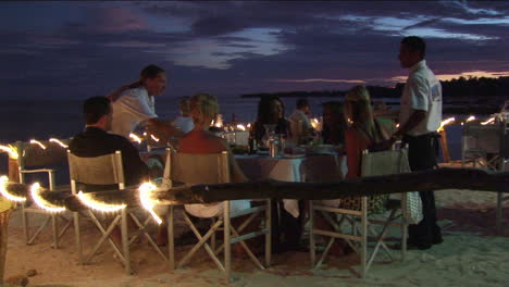 Los-Clientes-Cenan-En-Un-Restaurante-De-Playa-Al-Aire-Libre