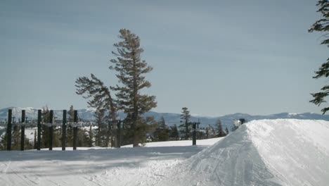 A-snowboarder-makes-a-jump-off-a-large-pile-of-snow