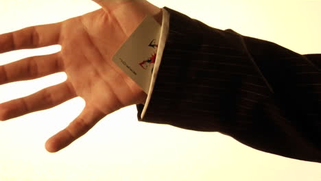 A-man-tucks-a-playing-card-into-his-shirt-sleeve
