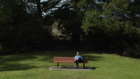 A-man-sits-on-a-park-bench-alone-with-a-flower