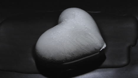 An-ice-heart-melts-on-a-dark-surface