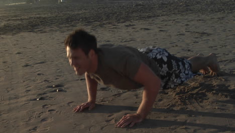 Un-Hombre-Hace-Flexiones-En-Una-Playa-De-Arena